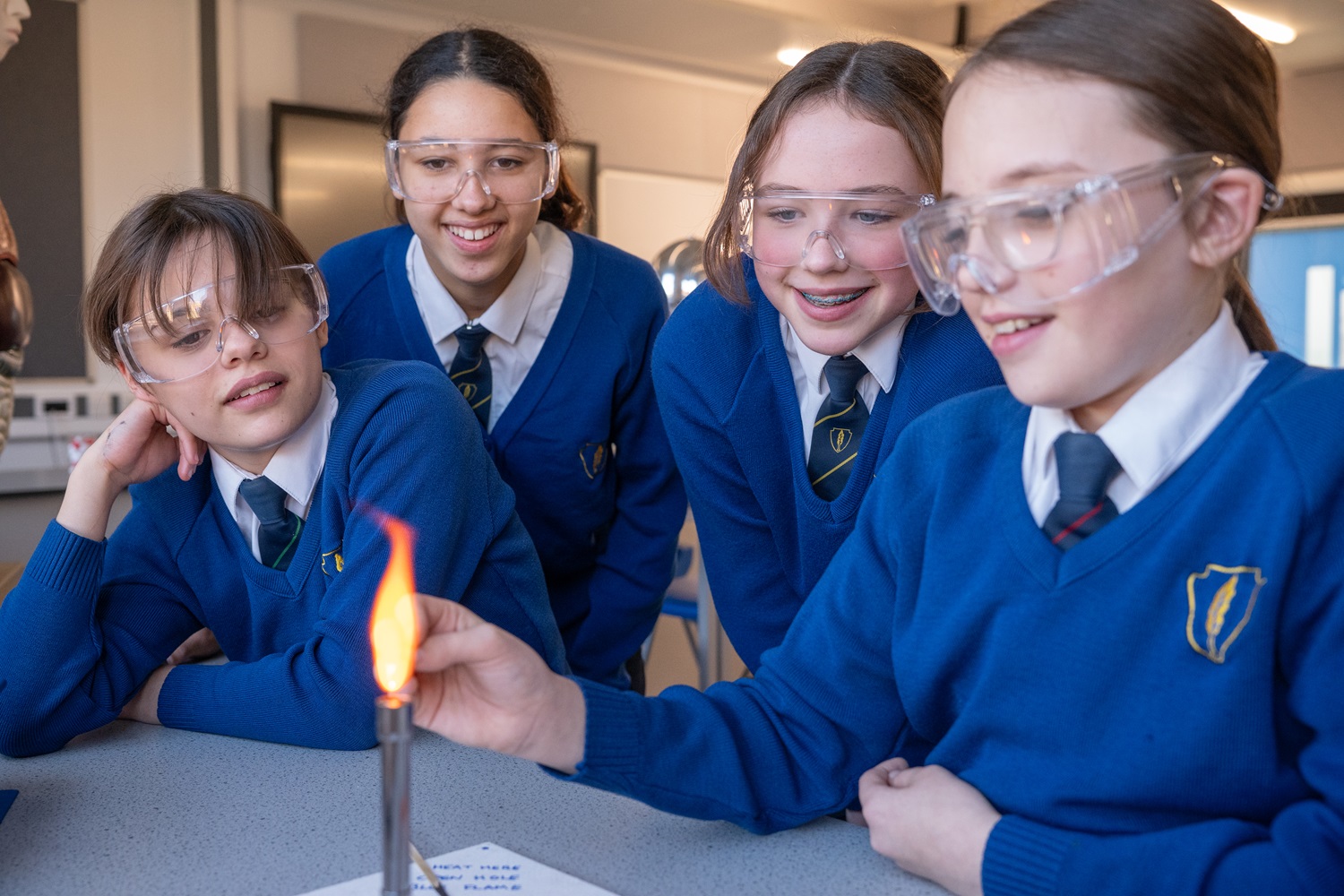 A photo of 4 students working with a bunsen burner